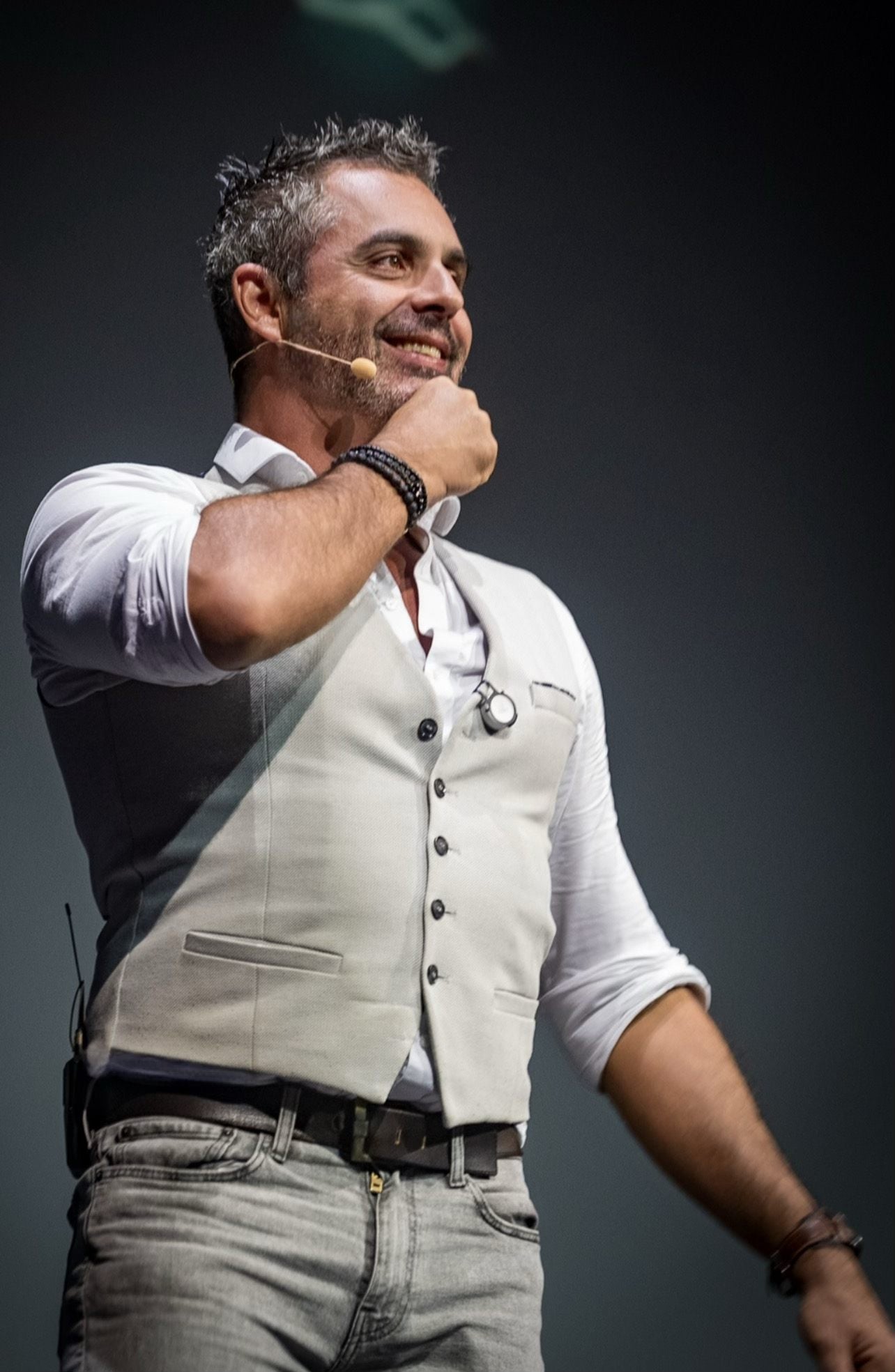 Phoenix mid-performance on stage, headset microphone, hand to his chin
