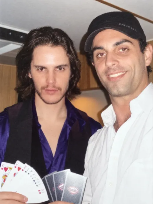 Phoenix on set with Taylor Kitsch, who is holding a fanned deck of cards, during X-Men Origins: Wolverine